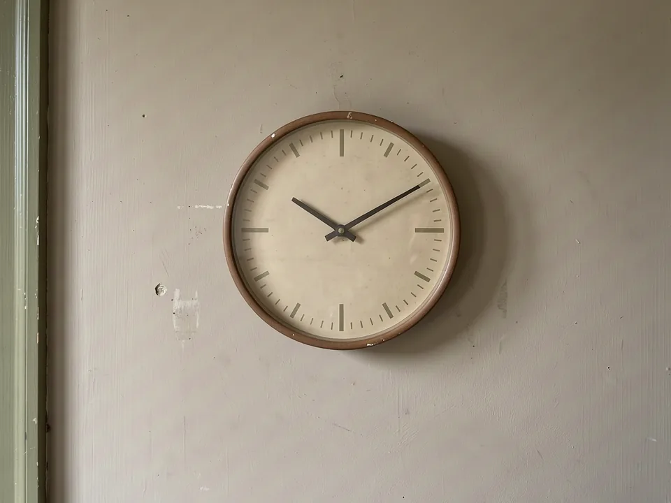 An unbranded wall clock with a plain face and simple hour marks.